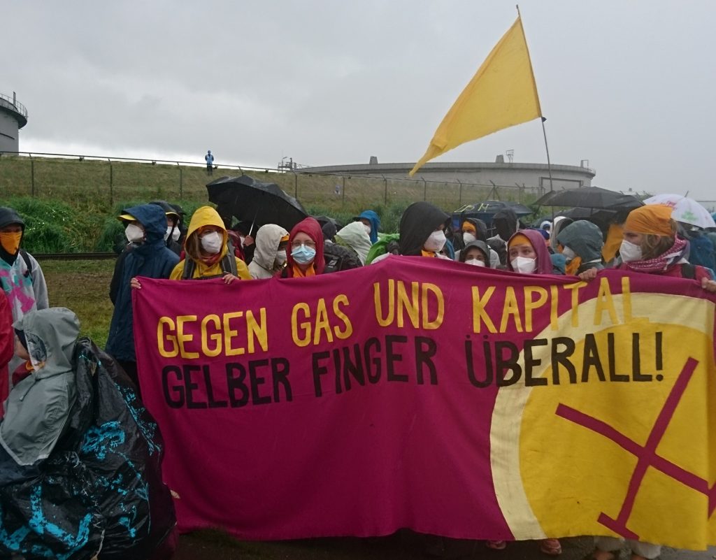 Ende Gelände activists carry a banner as they move together. 