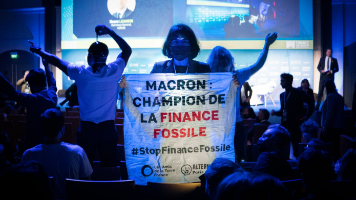 Activists cover themselves in fake oil at Climate Finance Day.